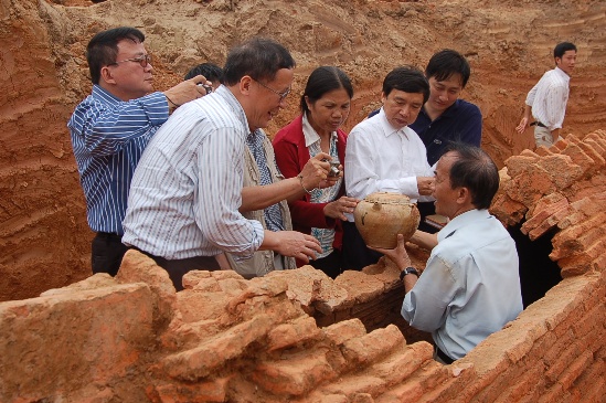PGS.TS Nguyễn Lân Cường đưa chiếc bình cổ hình đầu gà từ ngôi mộ ra. Đây là chiếc bình đẹp nhất được tìm thấy.